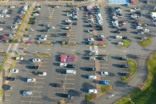 Aerial view of many colorful cars parked on parking lot with lines and markings for parking places and directions © bilanol