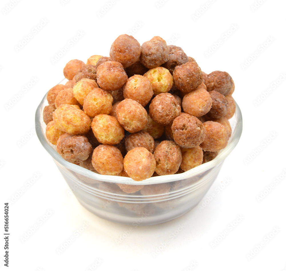Sweeteted crunchy corn cereal made with real peanut butter and cocoa in glass bowl on white Sweeteted crunchy corn cereal made with real peanut butter and cocoa in glass bowl on white