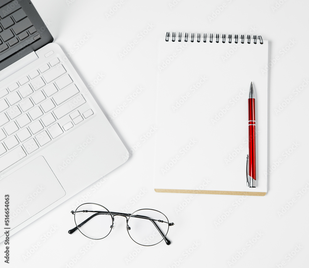 Laptop, notepad, pen and glasses on a white background. Laptop, notepad, pen and glasses on a white background.