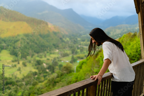 young latin long-haired man at a viewpoint in colombia Quindio, enjoying the mountainous scenery. copy space photo