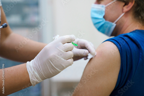 Man getting vaccinated against covid. Vaccination routine, adult immunization schedule. Seasonal virus protection, monkeypox vaccine. Outbreak disease prevention. Medical nurse hold injection syringe photo