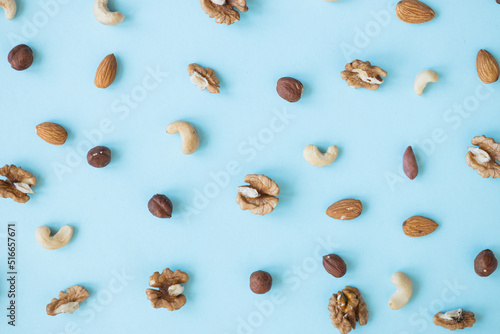 nuts mix for a healthy diet cashew, peanut, hazelnuts, walnuts, almonds on blue background