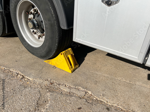 Yellow chock at the wheel of a parked truck