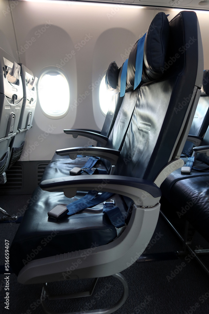Passenger plane interior details. Empty seats with safety belts. A moment before passengers board
