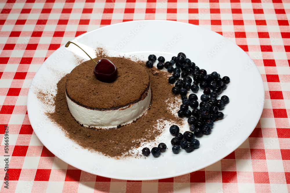 Ice cream sprinkled with chocolate with cherries and blueberries on a white plate. Ice cream sprinkled with chocolate with cherries and blueberries on a white plate.