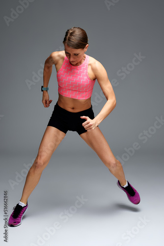 Fitness woman jumping and running, working out. Athletic girl doing jump © Georgii