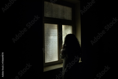 Horror woman in window wood hand hold cage scary scene halloween concept Blurred silhouette of witch. Horror theme