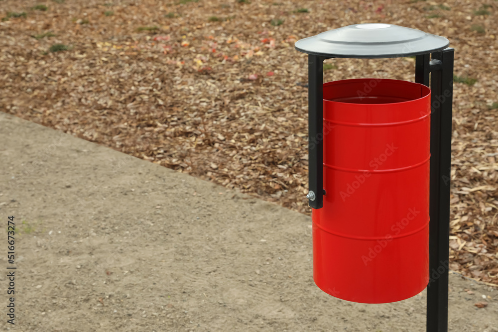 Red metal trash bin outdoors. Space for text Red metal trash bin outdoors. Space for text