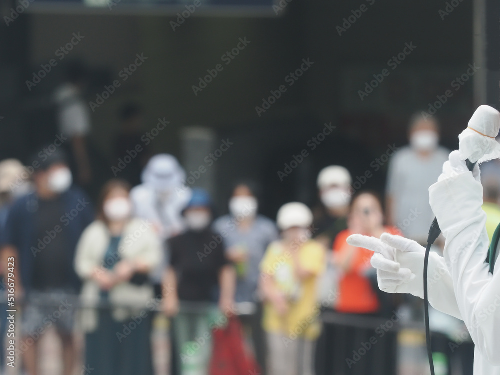 Fototapeta premium 選挙運動で街頭演説をする候補者とマスクをして聞く聴衆