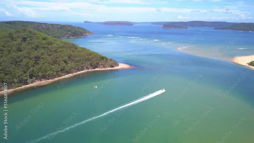 Beautiful epic aerial view of a speed boat passing the tropical island paradise with blue turquoise water Beautiful epic aerial view of a speed boat passing the tropical island paradise with blue turquoise water