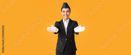 Beautiful stewardess on orange background photo