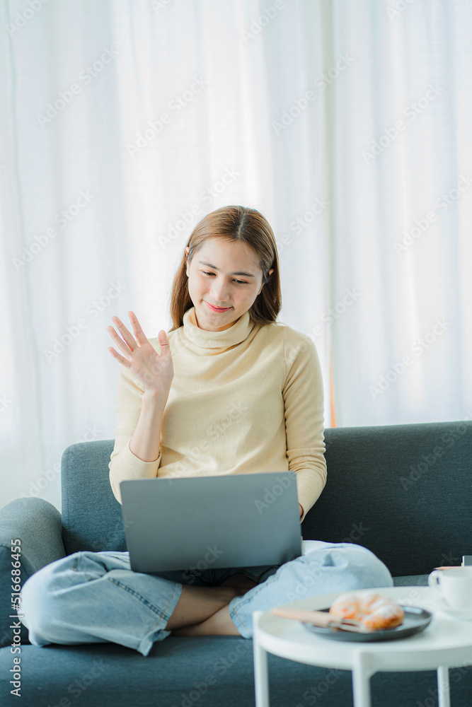 Attractive Asian woman relaxing on the sofa Use your laptop to work online at home and shop online. Attractive Asian woman relaxing on the sofa Use your laptop to work online at home and shop online.
