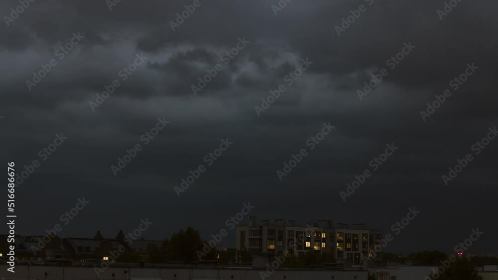 Thunderstorm with lightning over the night city, above the residential buildings. Thunderstorm with picturesque lightning illuminating the sky with orange and yellow colors. Thunderstorm with lightning over the night city, above the residential buildings. Thunderstorm with picturesque lightning illuminating the sky with orange and yellow colors.