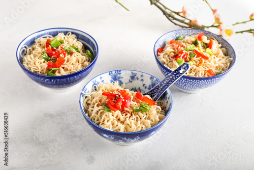 Bowl of tasty noodles on light background