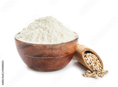 Bowl of flour and scoop with wheat grains on white background