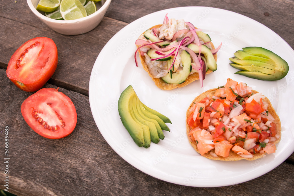 Tostadas de aguachile y ceviche con rebanadas de aguacate, jitomate y limones Tostadas de aguachile y ceviche con rebanadas de aguacate, jitomate y limones