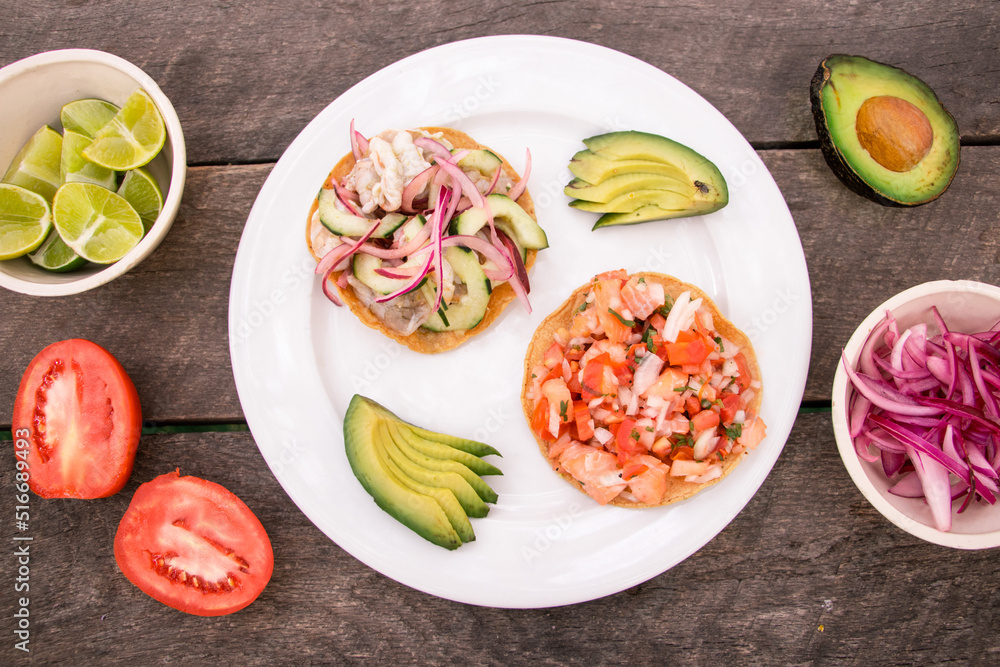 Tostada de aguachile y tostada de ceviche con rebanadas de aguacate, jitomate, limones y cebolla encurtida Tostada de aguachile y tostada de ceviche con rebanadas de aguacate, jitomate, limones y cebolla encurtida