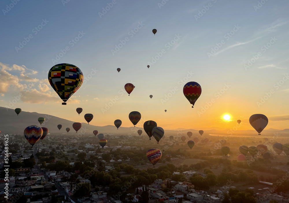 Obraz premium Colorful Hot Air Balloons Flying Over Ancient Pyramid of Teotihuacan, Mexico at sunrise -sunset, over the mist