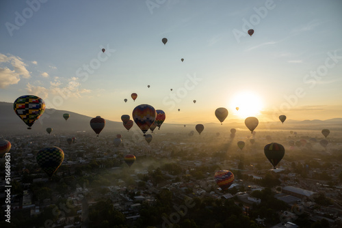 Colorful Hot Air Balloons Flying Over Ancient Pyramid of Teotihuacan, Mexico at sunrise -sunset, over the mist