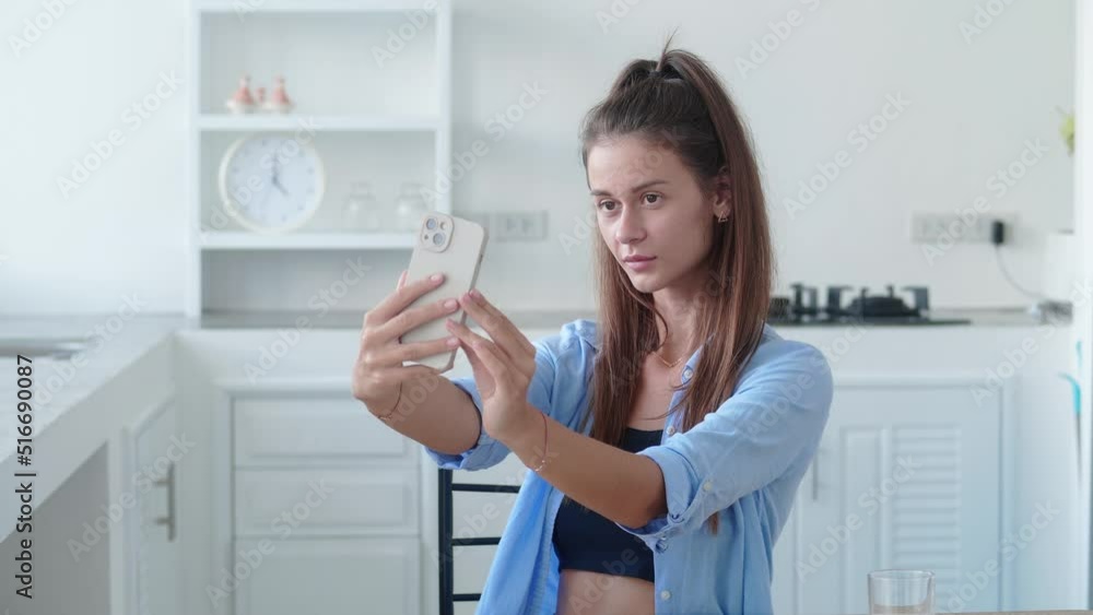 Portrait of woman taking selfie photo in modern kitchen. Colorful interior Portrait of woman taking selfie photo in modern kitchen. Colorful interior