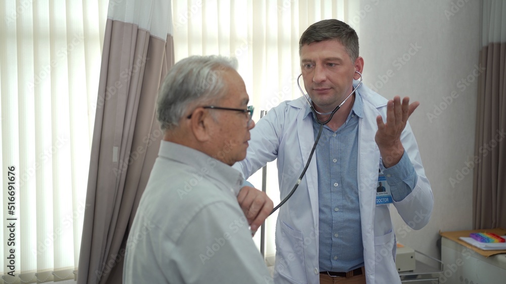 Asian elder adult having a consult with doctor about his disease, doctor checks respiratory system.