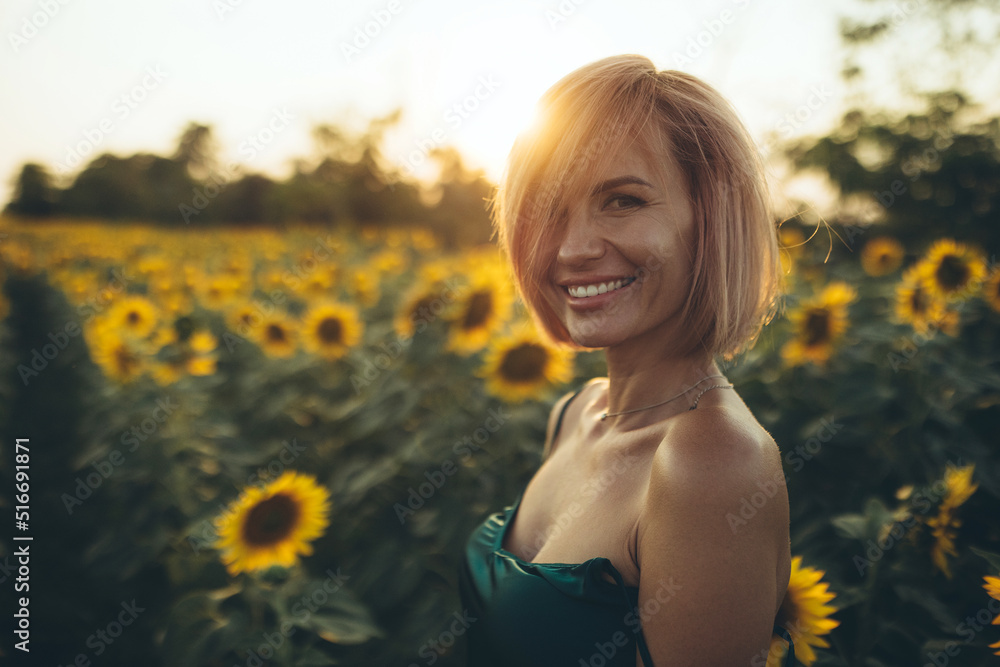 Beautiful woman in a field of sunflowers. Happy young woman in flowers in nature. High quality photo Beautiful woman in a field of sunflowers. Happy young woman in flowers in nature. High quality photo
