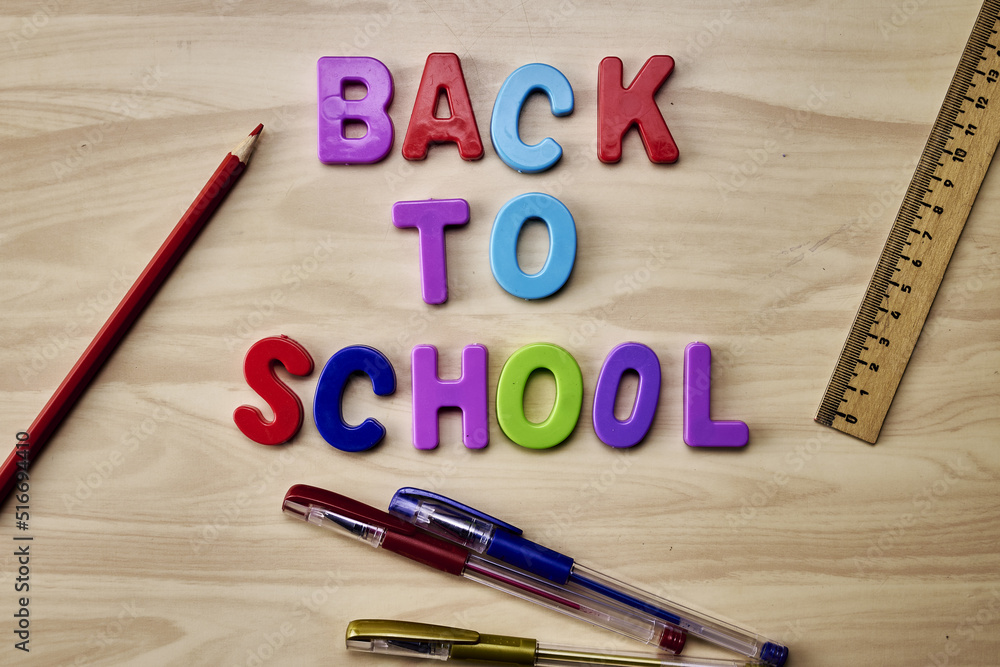 the phrase back to school is laid out in multicolored letters on the table next to colored pencils fountain pens and a ruler the concept of education school the phrase back to school is laid out in multicolored letters on the table next to colored pencils fountain pens and a ruler the concept of education school