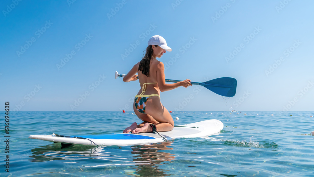 SUP Stand up paddle board. Young woman sailing on beautiful calm sea with crystal clear water. The concept of an summer holidays vacation travel, relax, active and healthy life in harmony with nature. SUP Stand up paddle board. Young woman sailing on beautiful calm sea with crystal clear water. The concept of an summer holidays vacation travel, relax, active and healthy life in harmony with nature.