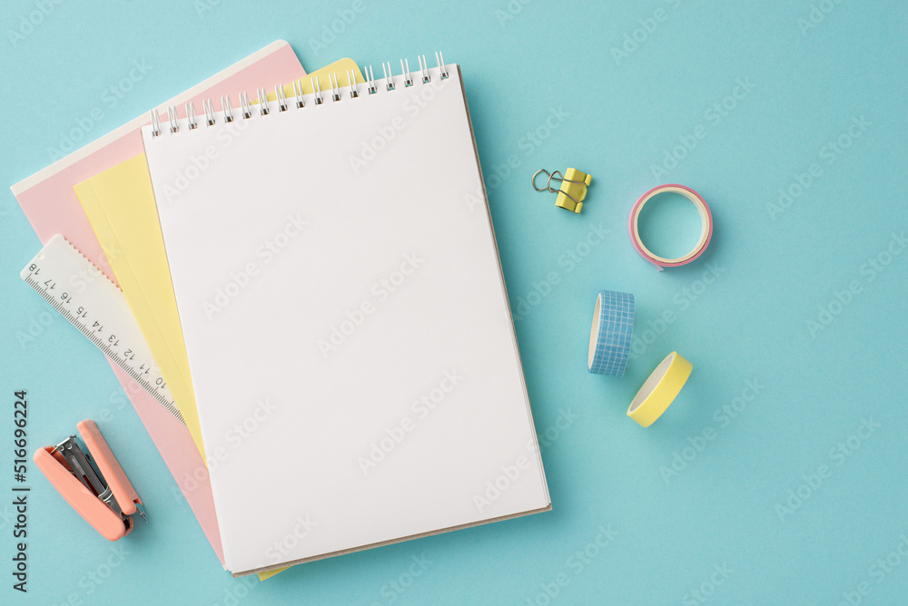 Back to school concept. Top view photo of school supplies open notepad ruler adhesive tape binder clip and stapler on isolated pastel blue background with blank space Back to school concept. Top view photo of school supplies open notepad ruler adhesive tape binder clip and stapler on isolated pastel blue background with blank space
