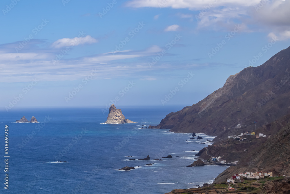 Scenic view of Atlantic Ocean coastline and Anaga mountain range on Tenerife, Canary Islands, Spain, Europe. Looking at small rocky island near the shoreline. Hiking trail from Afur to Taganana