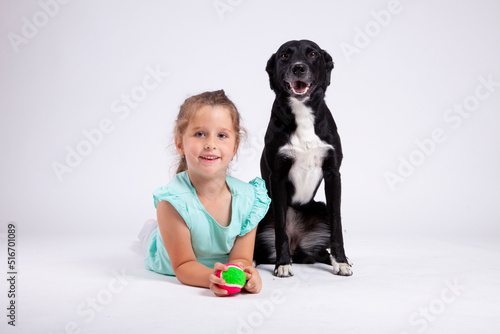 Cute little girl with her best pet friend black female dog on white backround.