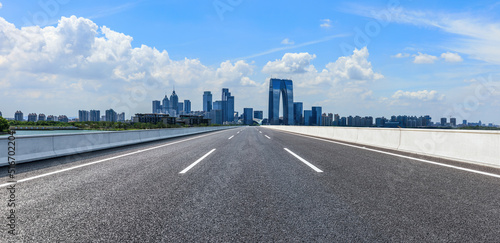 Cityscape of Suzhou City, Jiangsu Province, China. Straight asphalt road and modern city skyline background.