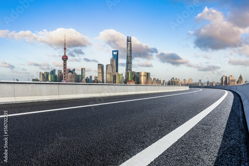 Empty asphalt road and city skyline with modern commercial buildings in Shanghai, China.