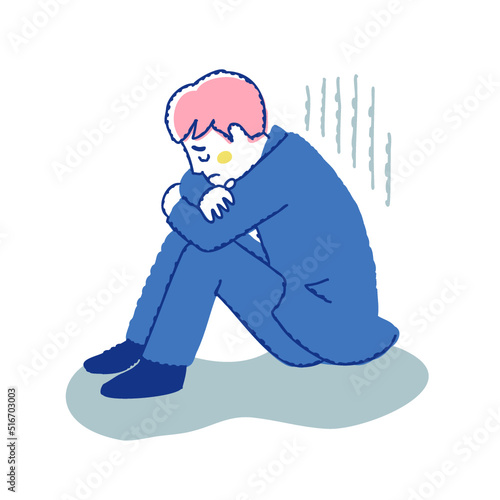 膝を抱えて落ち込んでいる男性