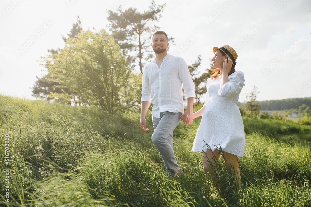 Happy and young pregnant couple hugging in nature Happy and young pregnant couple hugging in nature