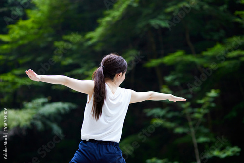 自然の中でストレッチを行う日本人女性