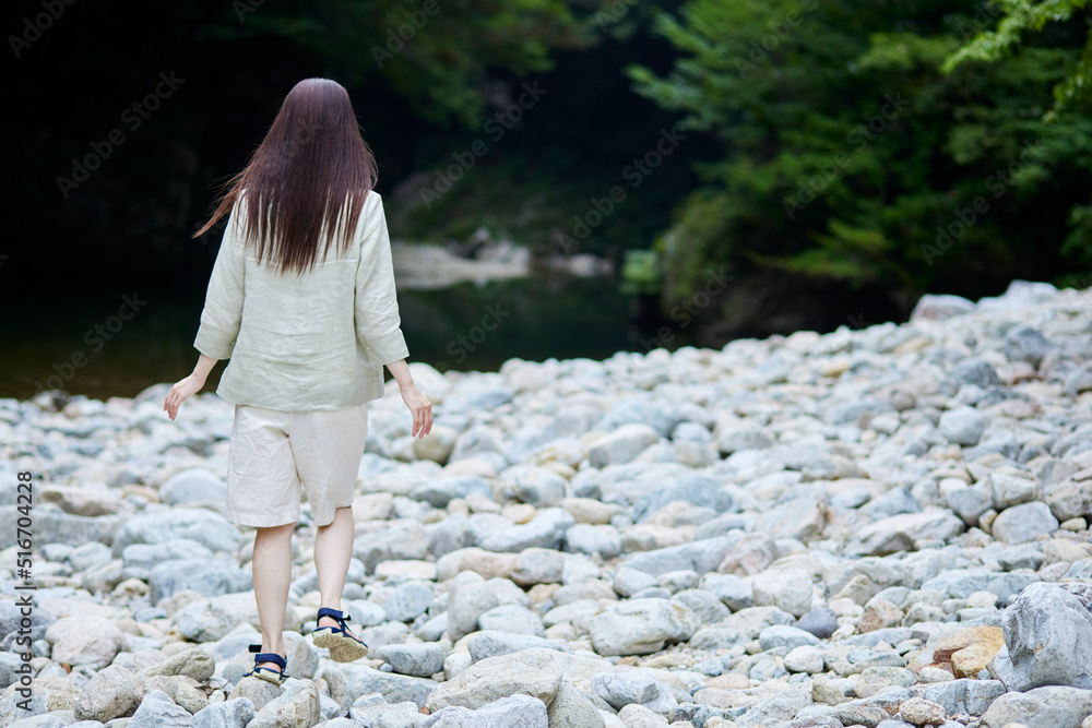 河原を歩く日本人女性の後ろ姿 河原を歩く日本人女性の後ろ姿