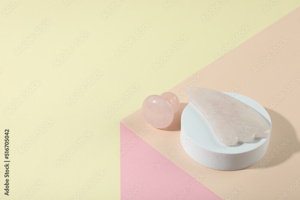 Face care concept with gua sha on soft three tone background Face care concept with gua sha on soft three tone background
