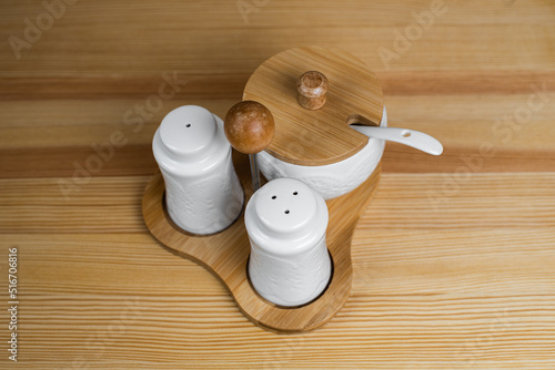 A kitchen set that includes sugar, pepper and salt with a spoon