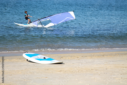 surfers surfing with windsurfing board in the sea