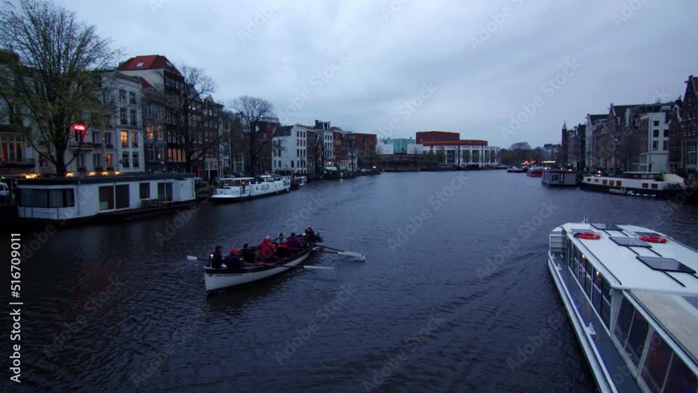 Amsterdam, Holland, Rowers and boat in water canal, Wide static shot, blue hour Amsterdam, Holland, Rowers and boat in water canal, Wide static shot, blue hour