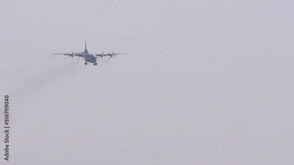 Turboprop military aircraft turboprop approaching to land, long shot. Heavy transport four-engine aircraft in the sky Turboprop military aircraft turboprop approaching to land, long shot. Heavy transport four-engine aircraft in the sky