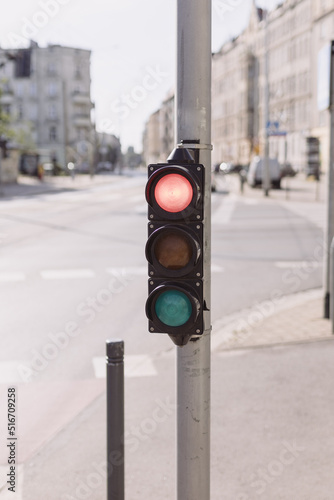 Red traffic light on a blurred buildings background