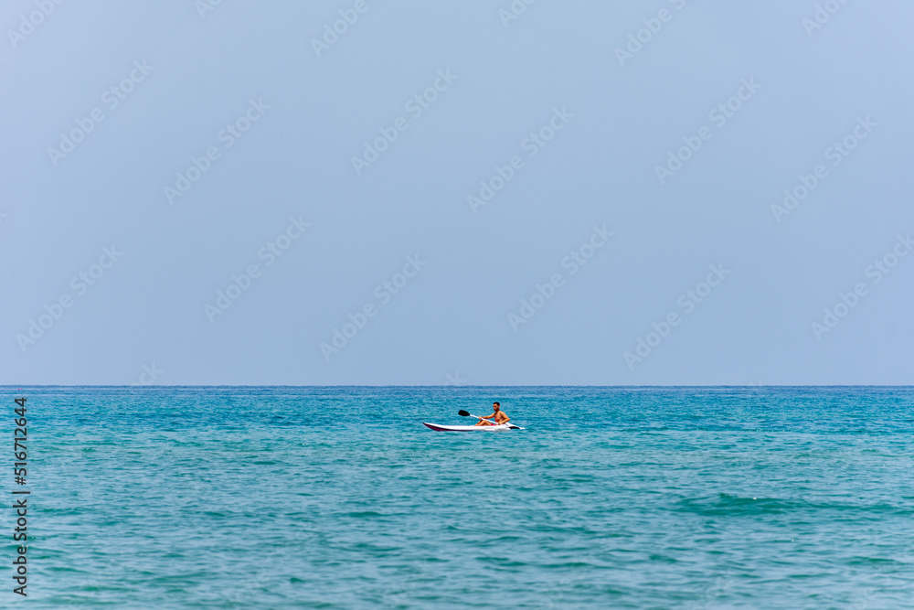 A young man kayaking in the Mediterranean sea. Kayaking sport concept. 