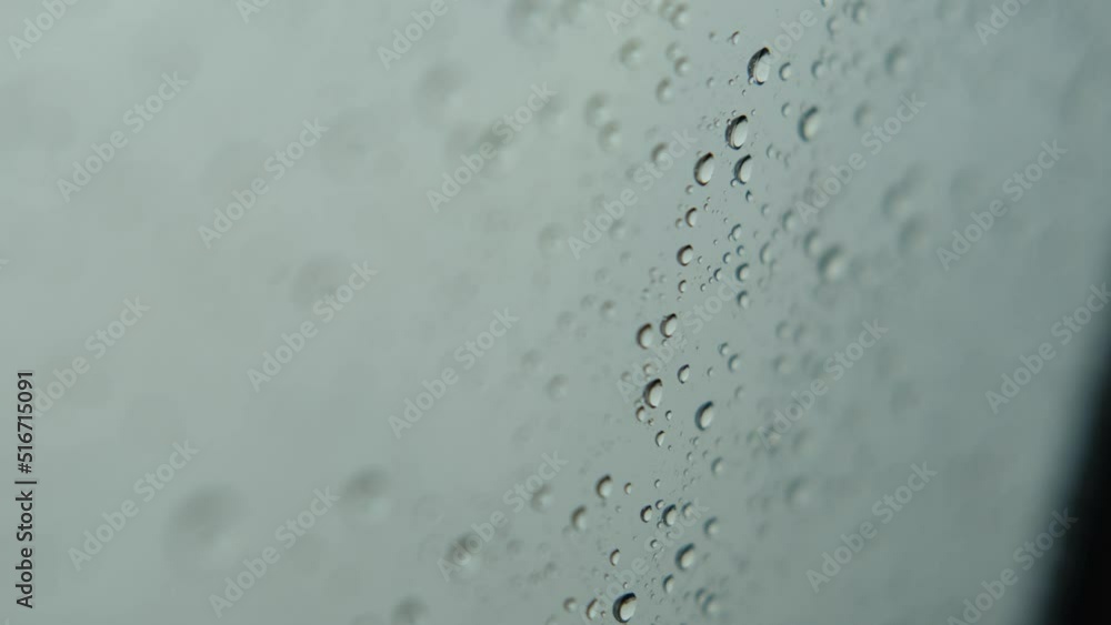 Droplets of Water on Glass running down. Drops of Rain trickling down