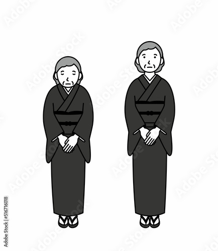 お辞儀をする喪服のシニア女性