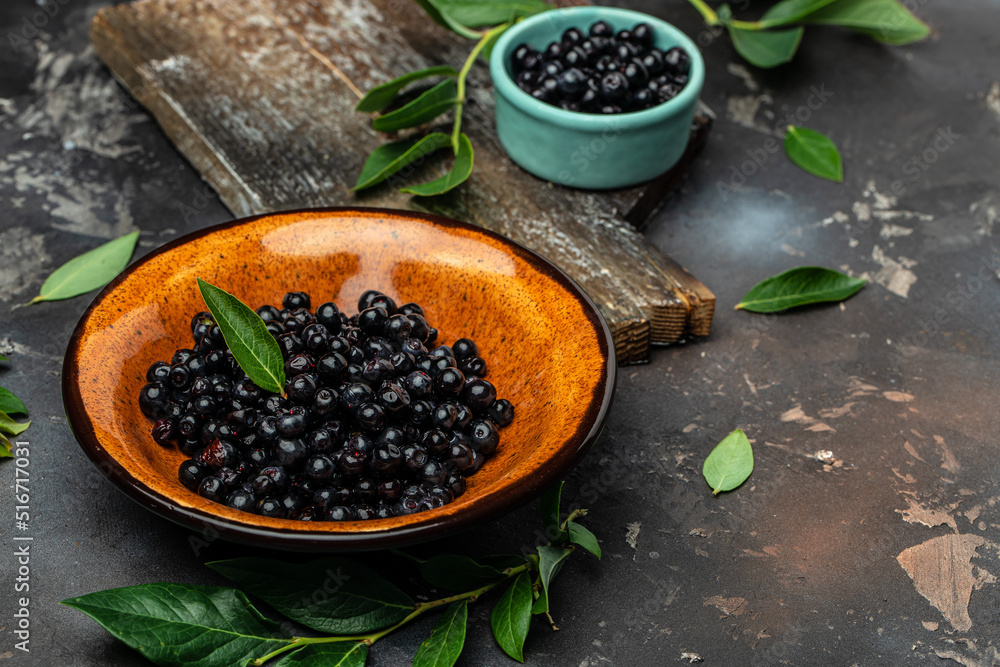 Superfoods antioxidant of indian mapuche. Bowl of fresh maqui berry on dark background, top view
