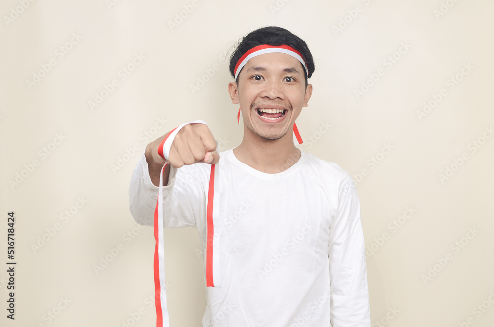 Asian man celebrating independence day while standing and clenching his hand Asian man celebrating independence day while standing and clenching his hand