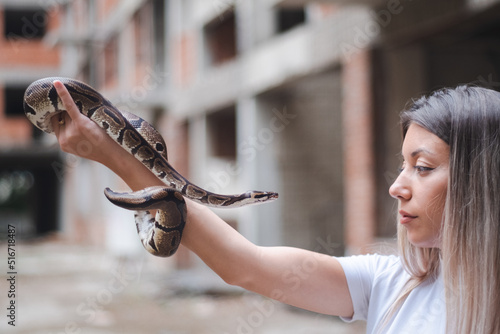 Long hair woman and a snake in the urban environment