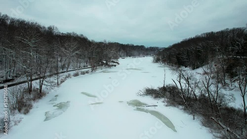 An aerial view of frozen creek in surrounded by forest and rockie mountains. An amazing view photo